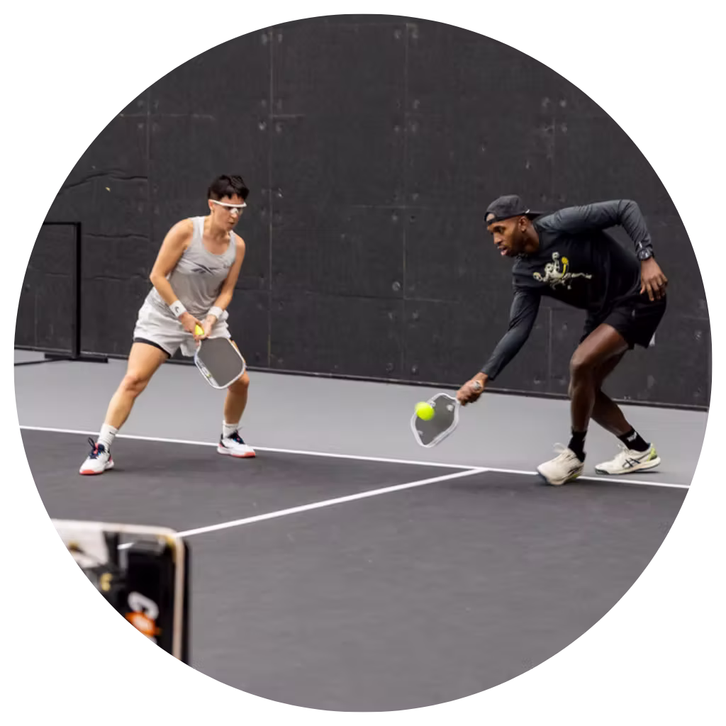 Mixed doubles pickleball players in action on indoor court at Apex Pickleball Clubs in Cedar Park Texas